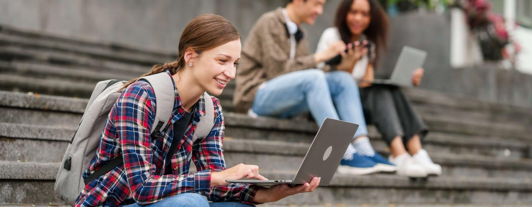 a group of people sitting on steps using laptops