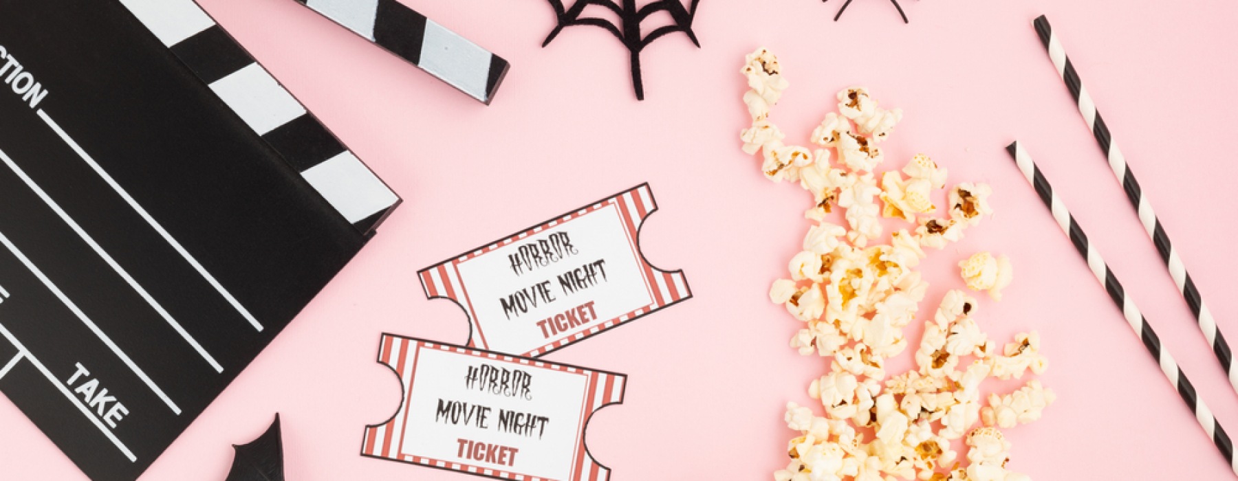 pink background with movie slice, movie tickets, popcorn, spiderweb, and black and white straws