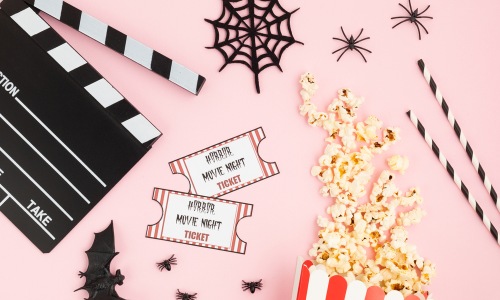 pink background, movie slicer, movie tickets, popcorn, spiderweb, and black and white straws