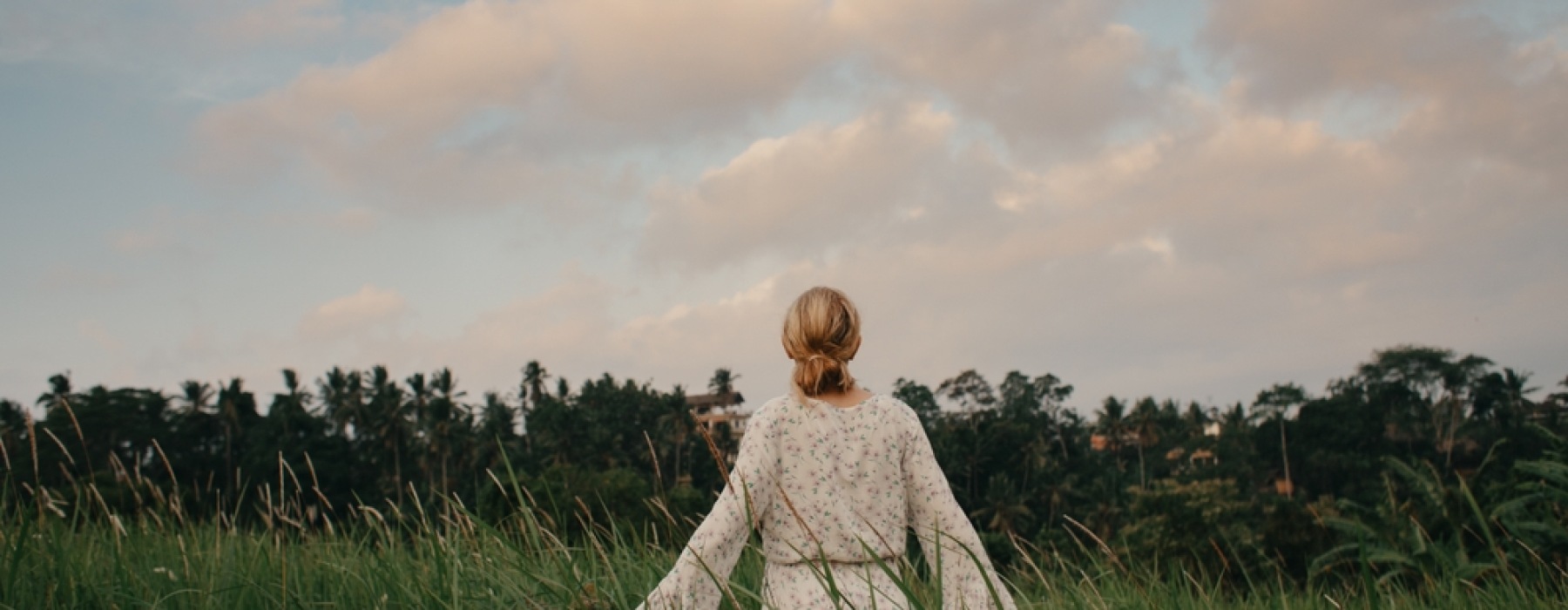 woman walking through tall grass