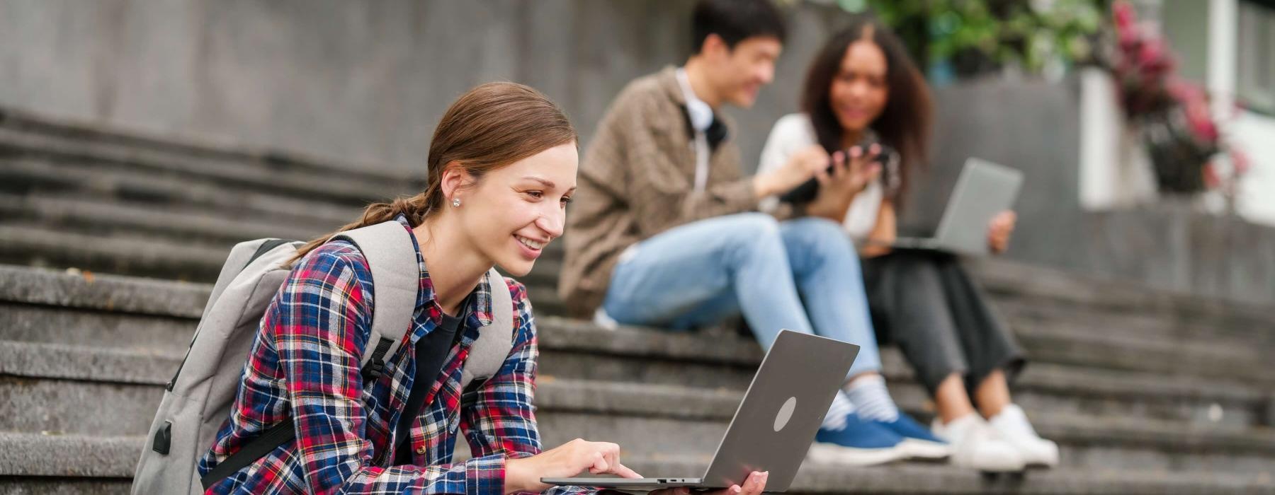 a group of people sitting on steps using laptops